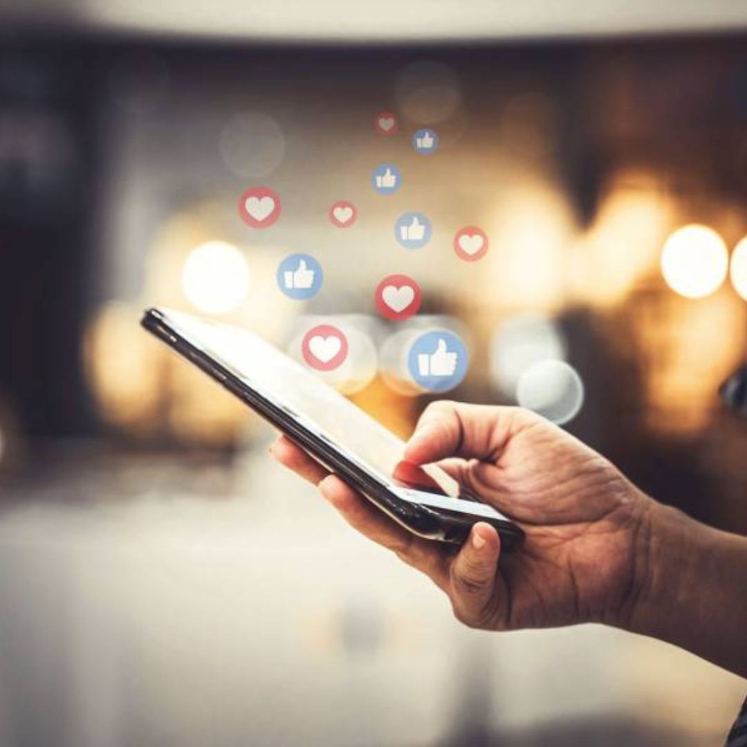 Hands holding smartphone with social media engagement icons showing successful account recovery